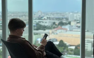A specialist taking a break in a lounge chair above the Bangkok skyline