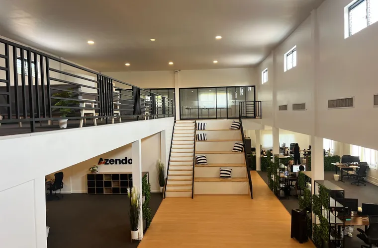 The open-plan Chiang Mai office where Azendo dedicated developers work, with its central staircase