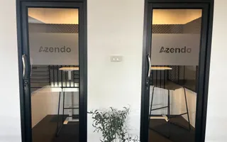 Two glass-fronted phone booths marked with the Azendo logo in the Chiang Mai office