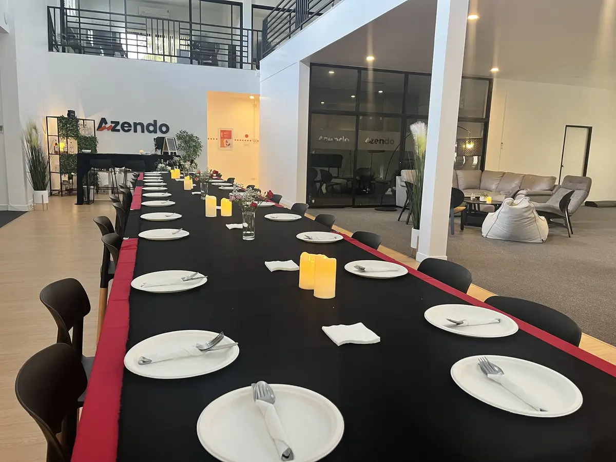 A long dinner table set for the whole managed team in the Azendo hall