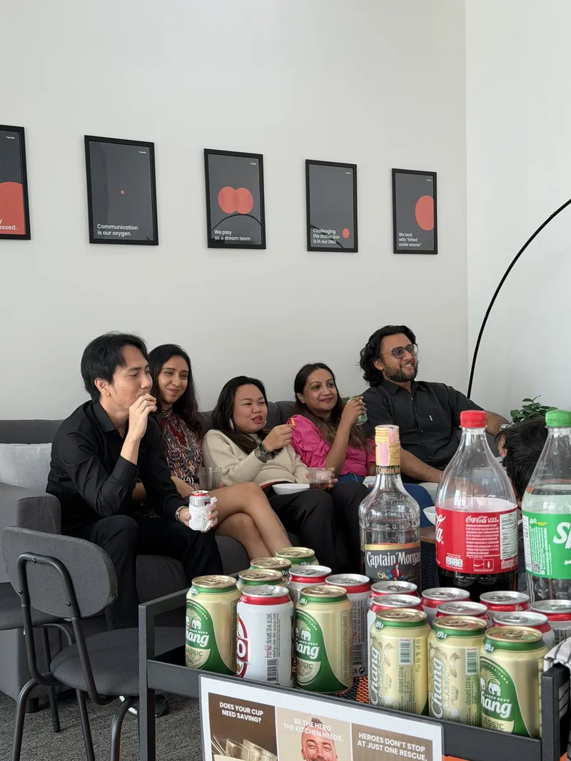 Team members on the office sofa under the values posters