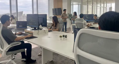 Offshore software developers coding at their desks in the Bangkok office