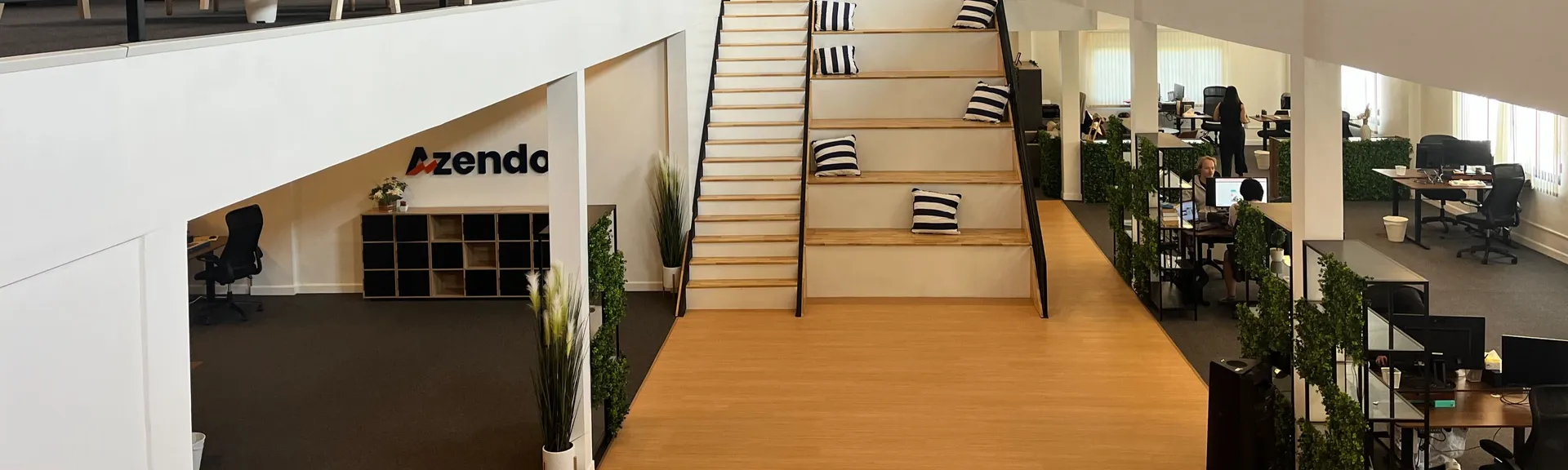 The open-plan Azendo office in Chiang Mai, with a central staircase and mezzanine