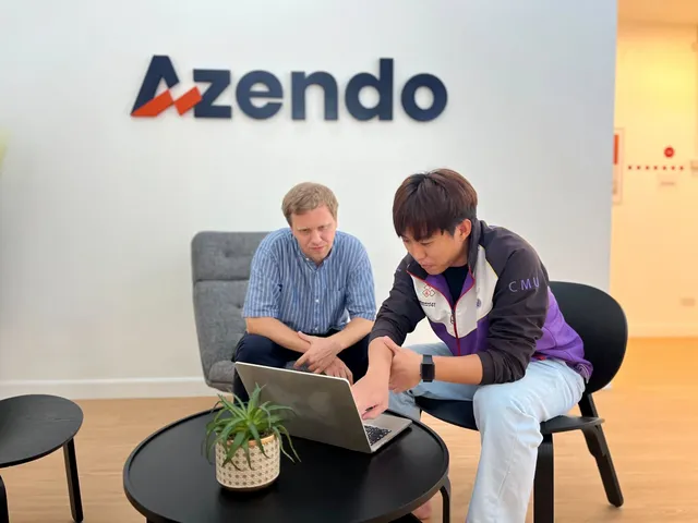Two Azendo colleagues reviewing work on a laptop in the Chiang Mai office reception