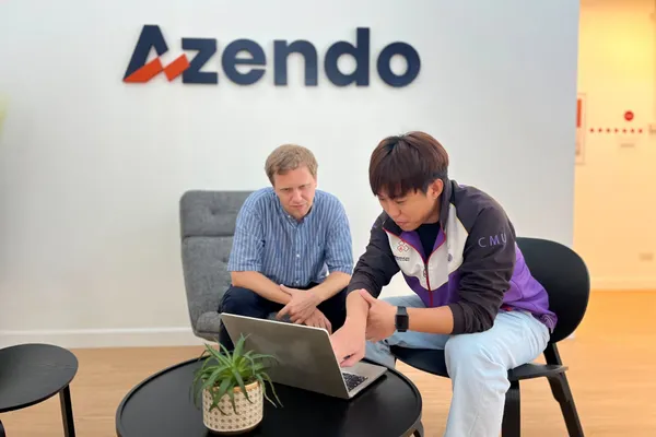 Two Azendo colleagues reviewing work on a laptop in the Chiang Mai office reception