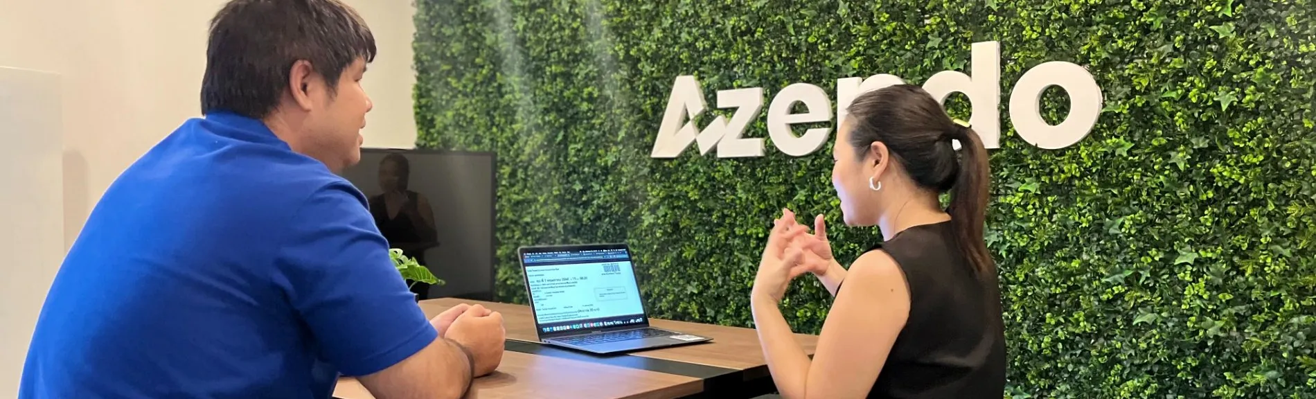 Two colleagues at a laptop in Chiang Mai, where Azendo assigns mobile app development