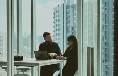 Two colleagues in a one-to-one meeting at a window table in the Bangkok office