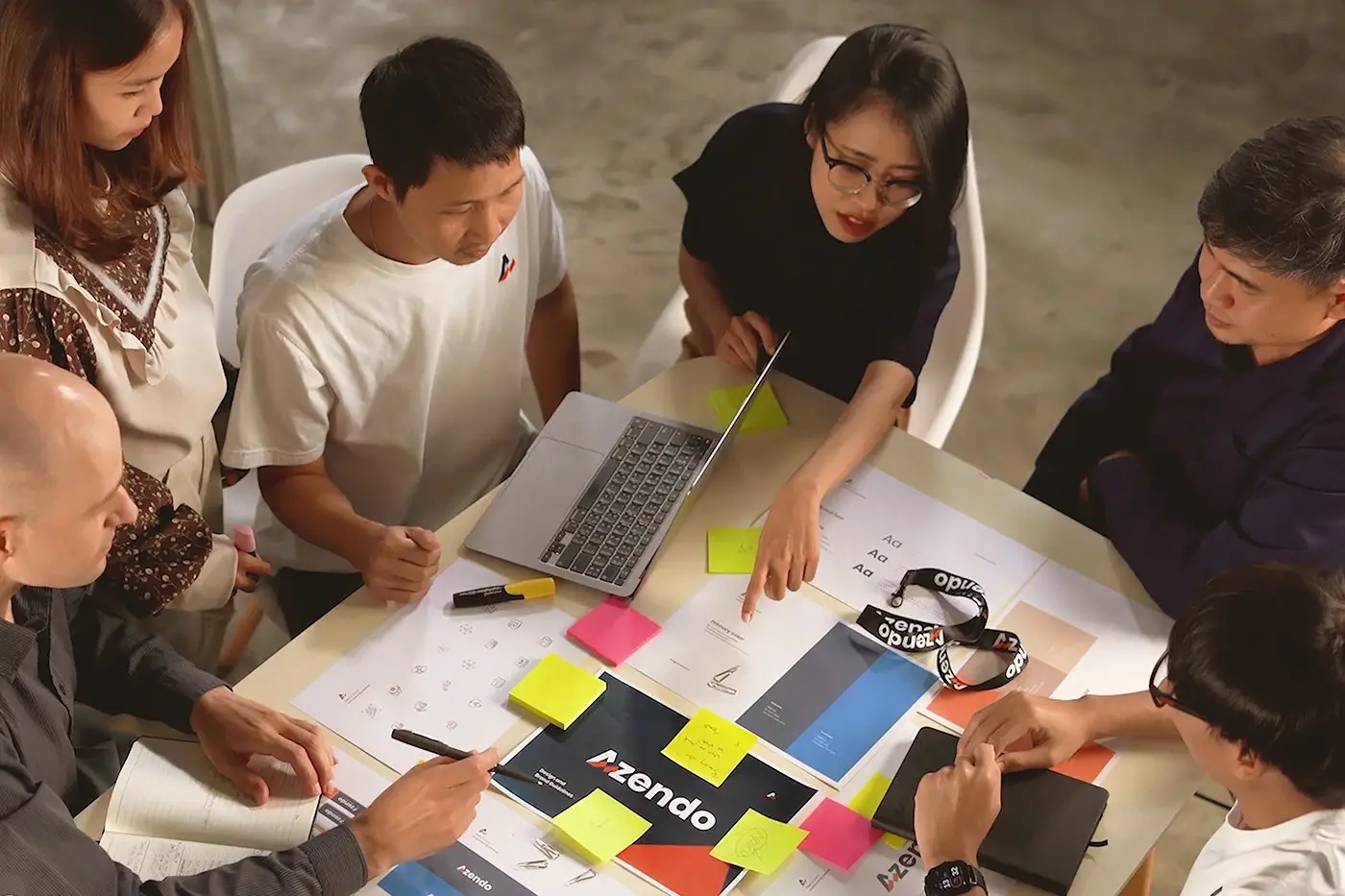 Our offshore development team working together around a table of sketches and sticky notes