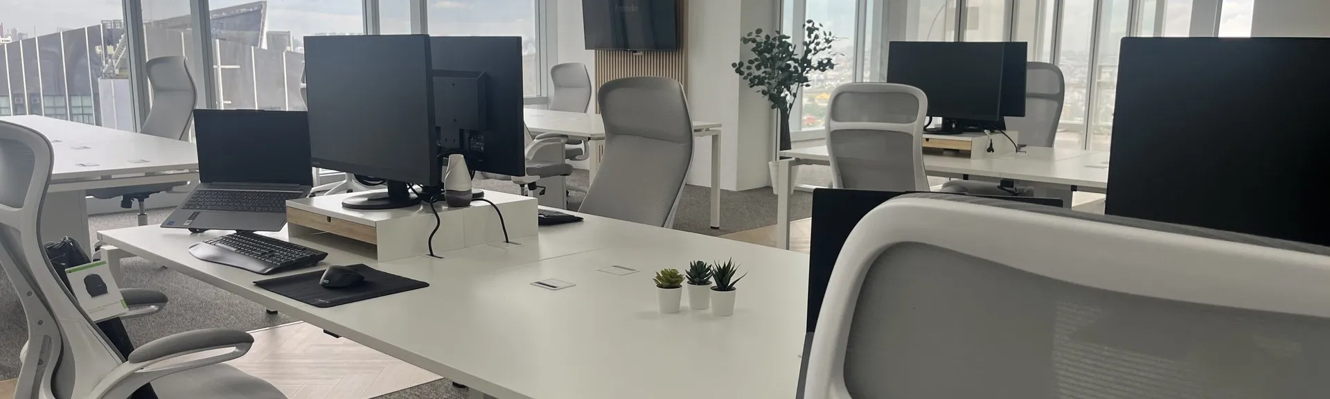 Desks and monitors at the Bangkok office where Azendo's outsourced UX design team works